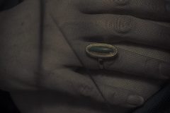 Fine art photograph of a hand with en dearest ring focused on light, composition, and a moment of stillness.