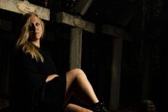 “Fine art portrait of strong woman in a minimal setting, focusing on stillness, light, and presence.”