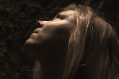 “Fine art portrait of strong woman in a minimal setting, focusing on stillness, light, and presence.”